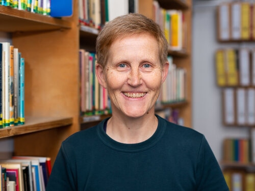 Auf dem Portrait ist Katja Koblitz vor einem Bücherregal zu sehen.